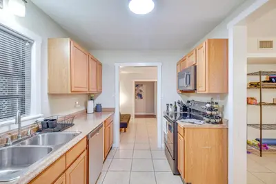 a kitchen with wooden cabinets and a sink at Patio and Grill Idyllic Sorrento Vacation Home! in Sorrento