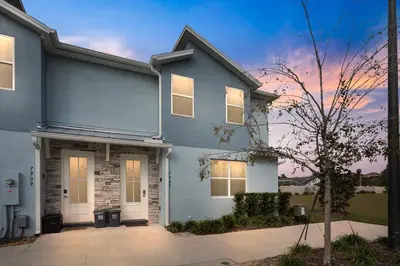 a blue house with a tree in front of it at Luxury Villa 5BedroomsPool- 4 miles from Disney in Orlando