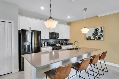 a kitchen with a large island with bar chairs at Stylish Family Home - Private Pool - STL111 in Kissimmee
