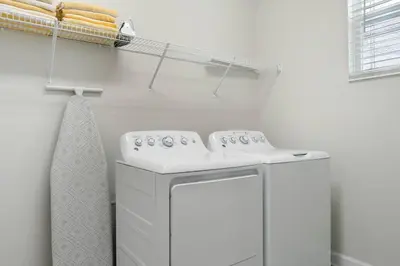 a white laundry room with a washing machine and a towel at Relax & Unwind Chic Pool Home Near Disney Fun! - STL113 in Kissimmee