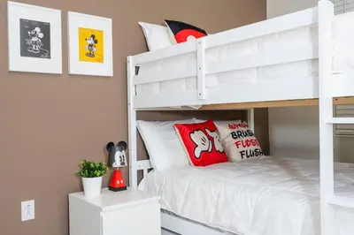 a bedroom with a white bunk bed with red pillows at Lovely Condo Access to Amazing Resort STL115 in Kissimmee