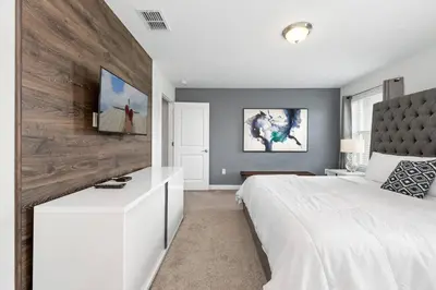 a bedroom with a white bed and a wooden wall at Really close to Disney! Sleeps 10 - STL116 in Kissimmee
