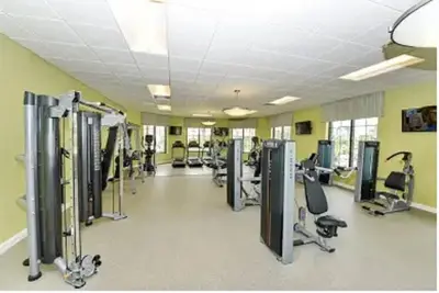 a gym with treadmills and machines in a room at Home away from Home! 6BR, 5.5 BA - STL118 in Kissimmee