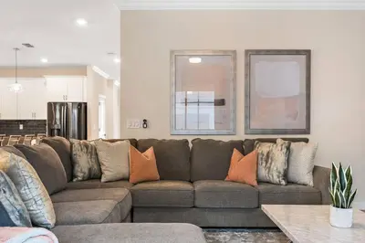 a living room with a brown couch with pillows at Home away from Home! 6BR, 5.5 BA - STL118 in Kissimmee