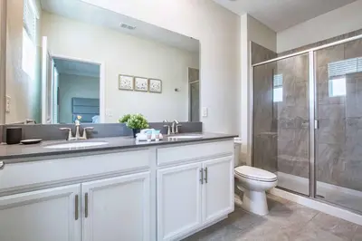 a bathroom with a toilet and a sink and a shower at Home away from Home! 6BR, 5.5 BA - STL118 in Kissimmee