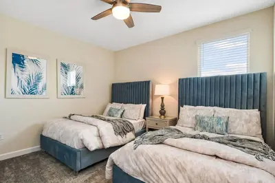 a bedroom with two beds and a ceiling fan at Home away from Home! 6BR, 5.5 BA - STL118 in Kissimmee