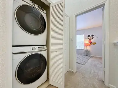 a laundry room with two washing machines and a window at Sunnyside Up Gated Resort Style Community in Orlando