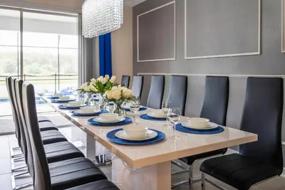 a long table with chairs and a dining room at Luxury Lake View 9-Bedroom Villa @Storey Lake Resort in Kissimmee