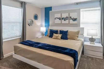 a bedroom with a large bed with blue walls at Luxury Lake View 9-Bedroom Villa @Storey Lake Resort in Kissimmee