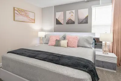 a bedroom with a large bed with pink pillows at Luxury Lake View 9-Bedroom Villa @Storey Lake Resort in Kissimmee