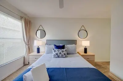 a bedroom with a large bed with two mirrors on the wall at 5 Bedroom villa with private pool, close to disney in Kissimmee