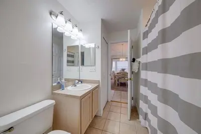 a bathroom with a sink and a toilet and a tub at 5 Bedroom villa with private pool, close to disney in Kissimmee