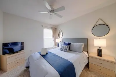 a bedroom with a bed and a ceiling fan at 5 Bedroom villa with private pool, close to disney in Kissimmee