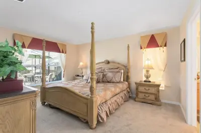 a bedroom with a four poster bed and a window at Florida Jewels - beautiful villa on Emerald Island in Kissimmee