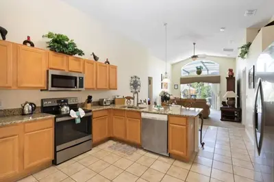 a large kitchen with wooden cabinets and appliances at Florida Jewels - beautiful villa on Emerald Island in Kissimmee