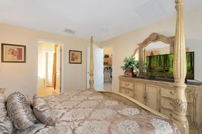 a bedroom with a large bed and a large mirror at Florida Jewels - beautiful villa on Emerald Island in Kissimmee