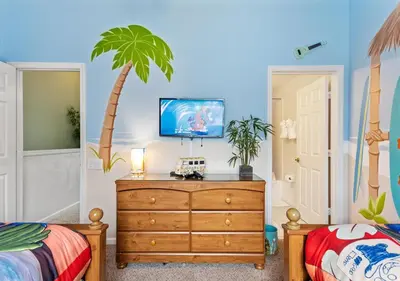 a bedroom with a dresser and a palm tree on the wall at Lilo and stitch Ohana Oasis in Kissimmee