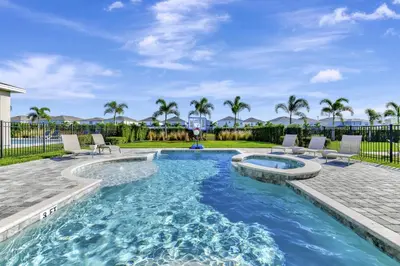 a swimming pool with lounge chairs and a swimming pool at Modern Home With Themed Rooms, Foosball Table And Waterpark & Resort Access Near Disney At Encore Resorts Reunion - 253Sf in Kissimmee