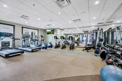 a gym with treadmills and machines in a room at Modern Home With Themed Rooms, Foosball Table And Waterpark & Resort Access Near Disney At Encore Resorts Reunion - 253Sf in Kissimmee