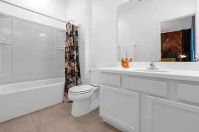 a white bathroom with a toilet and a sink at 30-Guest Home w Theme Rooms Games Resort Access in Kissimmee