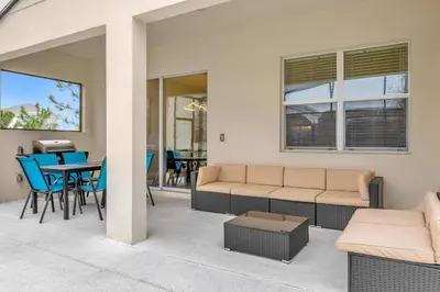 a living room with a couch and a table and chairs at 30-Guest Home w Theme Rooms Games Resort Access in Kissimmee