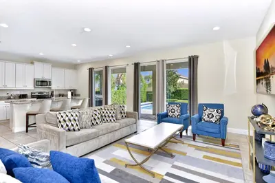 a living room with a couch and blue chairs at Glorious Home Near Disney With Private Pool, Game Room And Waterpark & Resort Access At Encore Resorts Reunion - 660La in Kissimmee