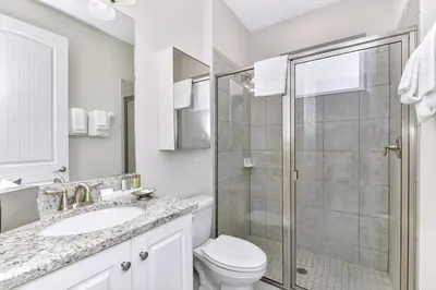 a bathroom with a shower and a toilet and a sink at Stylish Home With Themed Rooms, Game Room And Waterpark & Resort Access Near Disney At Encore Resorts Reunion - 267Sf in Kissimmee