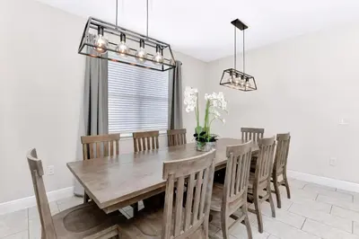 a dining room with a wooden table and chairs at Stylish Home With Themed Rooms, Game Room And Waterpark & Resort Access Near Disney At Encore Resorts Reunion - 267Sf in Kissimmee