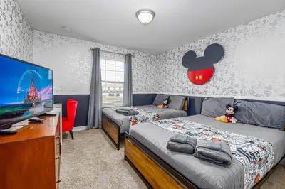 a bedroom with two beds and a flat screen tv at Amazing Townhouse at Storey Lake Resort in Kissimmee