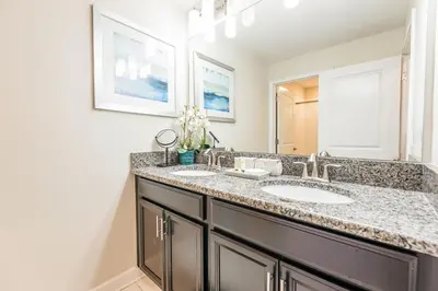 a bathroom with two sinks and a mirror at Amazing Townhouse at Storey Lake Resort in Kissimmee