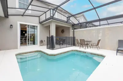 a swimming pool in a house with a table and chairs at Amazing Townhouse at Storey Lake Resort in Kissimmee