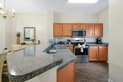 a kitchen with wooden cabinets and a counter top at Esmerald Island Resort Oasis: Your Perfect Getaway Near Disney in Kissimmee