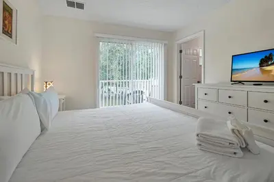a white bedroom with a large bed and a television at Esmerald Island Resort Oasis: Your Perfect Getaway Near Disney in Kissimmee