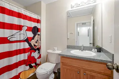a bathroom with a mickey mouse shower curtain and a sink at Esmerald Island Resort Oasis: Your Perfect Getaway Near Disney in Kissimmee