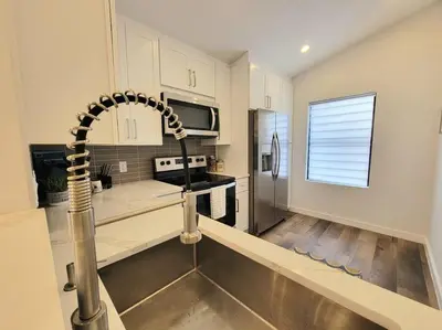 a kitchen with a sink and a stainless steel counter at Elegant Cozy Spot to unwind! UCF/MCO/Parks/Beach in Orlando