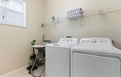 a laundry room with two white washes and a window at Amazing 6Bdrms At Storey Lake- Close to Disney in Kissimmee