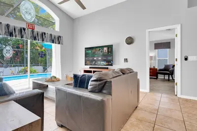 a living room with a couch and a tv at South Facing Pool with Spa and a Game Room in Prime Location Near Disney in Kissimmee