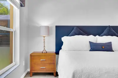 a bedroom with a bed with a blue headboard and a nightstand at South Facing Pool with Spa and a Game Room in Prime Location Near Disney in Kissimmee