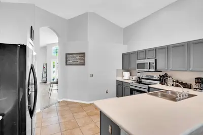 a kitchen with a black refrigerator and a counter top at South Facing Pool with Spa and a Game Room in Prime Location Near Disney in Kissimmee