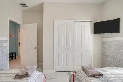 a bedroom with two beds and a flat screen tv at Kissimmee Getaway with Pool Access 5 Mi to Disney in Kissimmee