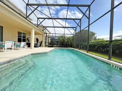 a swimming pool in the backyard of a house at Sunnyside Villa home in Kissimmee