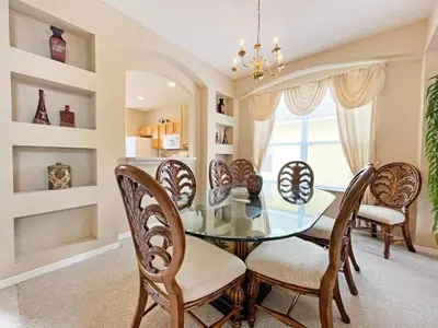 a dining room with a glass table and chairs at Sunnyside Villa home in Kissimmee