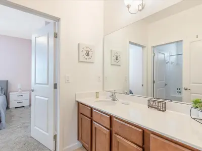 a bathroom with a sink and a mirror at 6BR w Heated Pool + 9MI to Disney + Sleeps 14 in Kissimmee