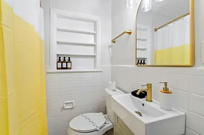a bathroom with a sink and a toilet and a mirror at Fire Pit + Grill + 2MI to DT Orlando in Orlando