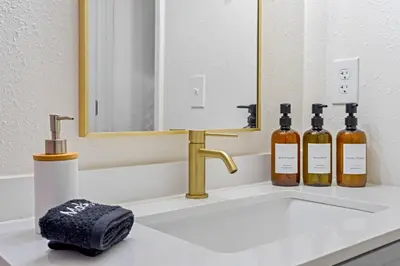three bottles of wine sitting on a bathroom sink at Fire Pit + Grill + 2MI to DT Orlando in Orlando