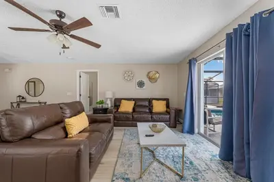 a living room with a couch and a ceiling fan at 4BR w Heated Pool near Disney & Lake - Sleeps 10 in Kissimmee