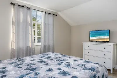 a bedroom with a bed and a tv on a dresser at 4BR w Heated Pool near Disney & Lake - Sleeps 10 in Kissimmee