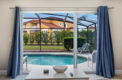 a view of a swimming pool through a sliding glass door at 4BR w Heated Pool near Disney & Lake - Sleeps 10 in Kissimmee