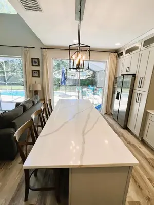 a kitchen and living room with a large white table at Enchanted Hideaway in Kissimmee