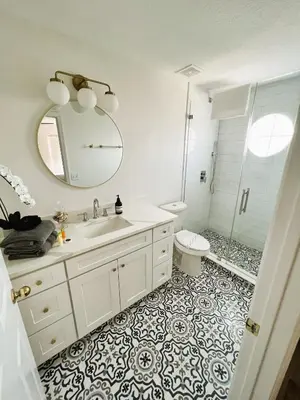 a bathroom with a sink and a toilet and a mirror at Enchanted Hideaway in Kissimmee
